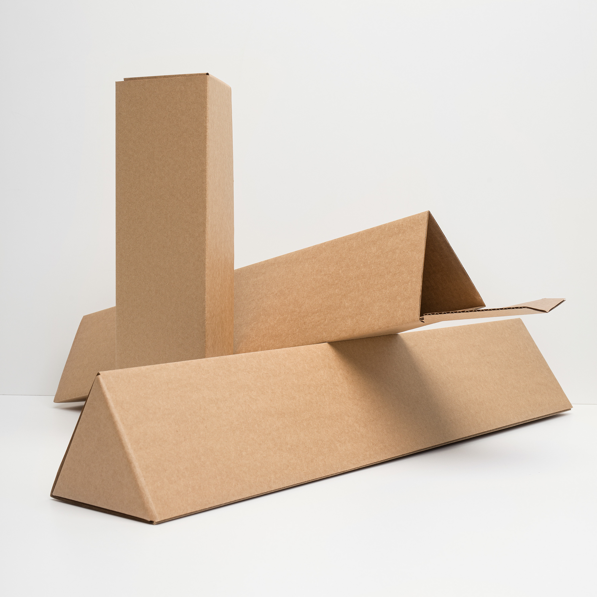 Cardboard boxes of different sizes on a white background that are used for shipping the paper prints
